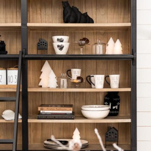 bibliothèque en bois noir et naturel avec échelle en bois noir 4 étagères avec bibelots blanc et noir avec une vu zoomé