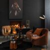 canapé en velours marron Elisabeth et pieds en métal or dans un salon avec un cadre représentant une tête de cheval marron sur un mur noir un fauteuil jaune moutarde est situé sous le cadre avec un tapis noir