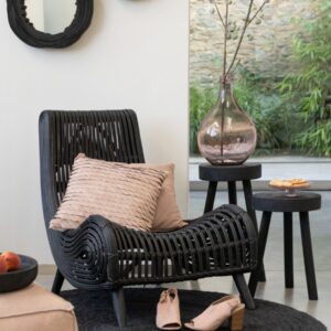 fauteuil lounge en rotin noir miroir rond en bois de manguier noir vase translucide rose pâle tables gigognes en bois de manguier noir tapis rond en jute noir pouf carré en cuir rose