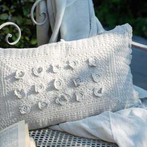 coussin rectangle dentelles en coton bleu posé sur un plaid bleu ciel