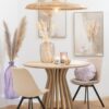 suspension en rotin table ronde en bois de manguier naturel chaises beiges avec pieds en métal noir vase haut translucide violet avec herbes pampas vase haut transparent blanc cadre gris et beige coussin violet rond dentelles en coton