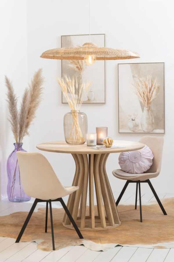 suspension en rotin table ronde en bois de manguier naturel chaises beiges avec pieds en métal noir vase haut translucide violet avec herbes pampas vase haut transparent blanc cadre gris et beige coussin violet rond dentelles en coton