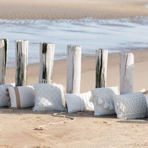 coussin en coton représentant des losanges sur une plage au bord de l'eau aligné avec d'autres coussins
