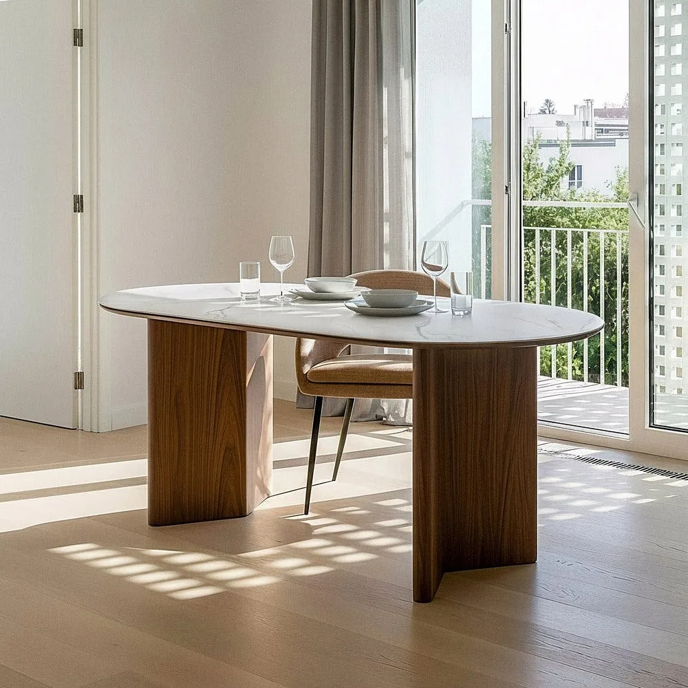 Table à manger ovale céramique effet marbre Ixia 180 cm dressée devant une baie vitrée